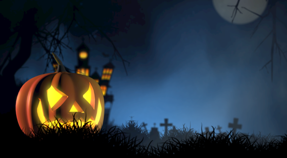 citrouille halloween dans la nuit éclairée devant château et cimetière