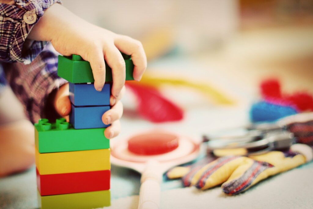 mains enfants qui emplilent cubes multicolores