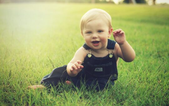 bébé assit dans l'herbe