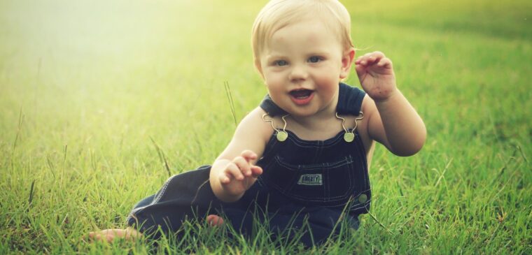 bébé assit dans l'herbe