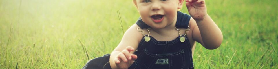 bébé assit dans l'herbe