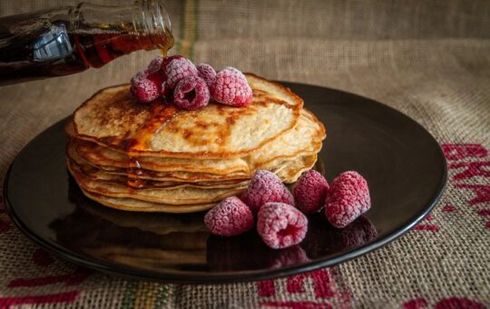 crêpes avec framboise et sirop érable dans assiette noire