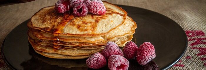 crêpes avec framboise et sirop érable dans assiette noire