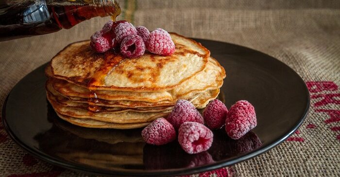 crêpes avec framboise et sirop érable dans assiette noire