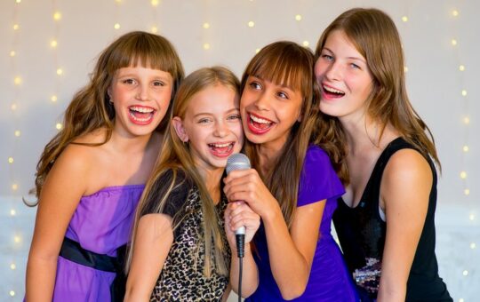 quatre jeunes filles en robe de soirée noires et violettes sourient