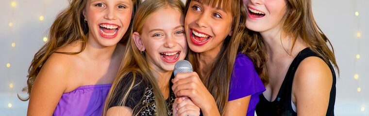 quatre jeunes filles en robe de soirée noires et violettes sourient