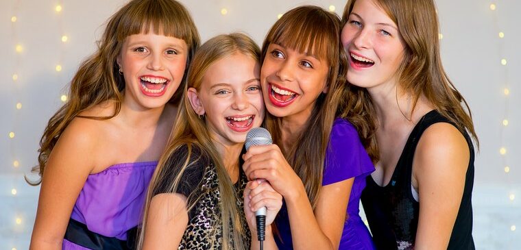 quatre jeunes filles en robe de soirée noires et violettes sourient