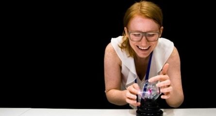 femme en blanc fait expérience scientifique sur table