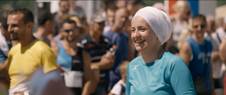 femme voilée habillée en bleu qui sourit