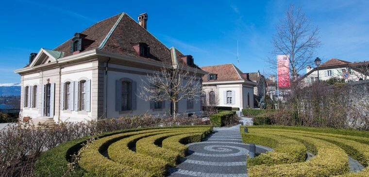 jardin français et bâtiment sous ciel bleu