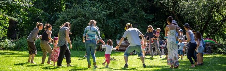 enfants et adultes font la ronde dans un parc