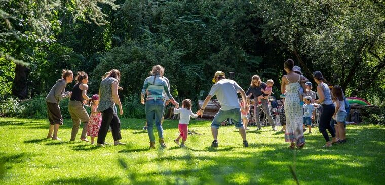 enfants et adultes font la ronde dans un parc