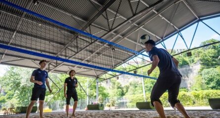 trois hommes jouent au volley ball