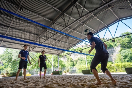 trois hommes jouent au volley ball